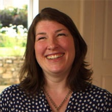 A smiling person with brown hair in a polka dot shirt embodies digital healthcare innovation in healthcare education, reflecting medbridge's future vision.