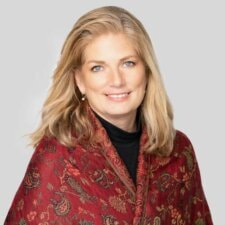 A smiling person with long blonde hair in a red patterned shawl illustrates medbridge's nurturing healthcare education.