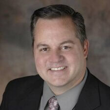 Smiling man in a suit represents Medbridge's innovative digital healthcare education.