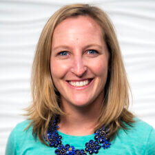 A smiling person with blonde hair and a turquoise top embodies the positive energy of Medbridge against a wavy white background.