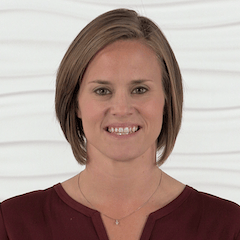 Smiling person in maroon top symbolizes enthusiasm for healthcare education against a white textured background, linked to medbridge.
