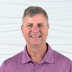 A man in a purple shirt smiles, representing medbridge and the bright future of digital healthcare.