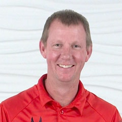 A smiling person in a red shirt represents medbridge's positive impact on digital healthcare.