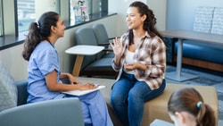 Clinician and patient talking in a healthcare setting, demonstrating active listening in healthcare through open, engaged body language.