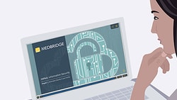 Individual viewing a laptop with a medbridge-branded information security presentation showing a digital lock graphic.