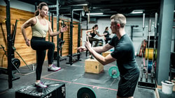 man helping woman exercise on box - CSCS CEU Requirements