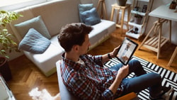 A man has a video call on a tablet for digital healthcare with medbridge.