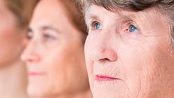 Three women of different ages are shown in profile, with the focus on the elderly woman in the foreground.