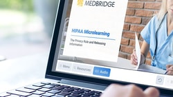 A person uses a laptop showing a medbridge HIPAA Microlearning course featuring a healthcare professional.