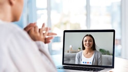 Video call on a laptop with Medbridge in a bright room.