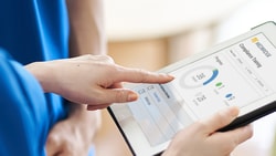 User interacting with a tablet showing the medbridge health app.