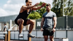 Two men in athletic gear exercise outdoors, highlighting physical activity for medbridge digital healthcare.