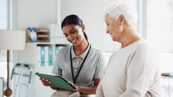 Clinician reviewing remote therapeutic monitoring data with senior patient on tablet