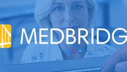 A laptop screen with a medbridge logo shows a video call with a woman and a hand near the keyboard.
