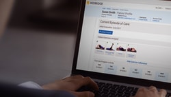 Person looking at a laptop showing the medbridge medical portal with patient info and exercise tasks.