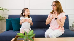 Child and therapist practicing breathing techniques together to support self-regulation in childhood during a therapy session.