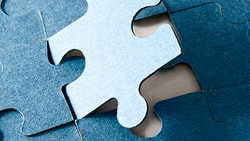 A blue puzzle piece fitting into place on a medbridge puzzle.