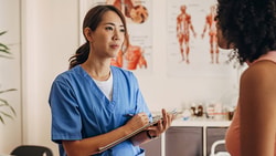 A healthcare professional talks to a patient in an office with Medbridge branding.