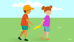 A boy in orange playfully tugs a yellow ribbon from a girl's pink shirt in a grassy field.