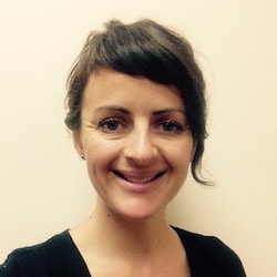 A woman with short brown hair, wearing a black top, smiles at the camera, representing professionalism in digital healthcare for medbridge.