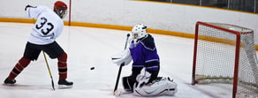 A red and white hockey player shoots the puck at a purple and black goalie, symbolizing precision similar to Medbridge software.