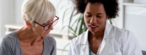 A healthcare professional reviews paperwork with a patient using Medbridge software.