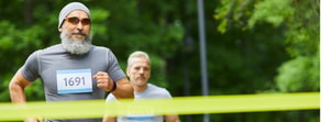 Two men sprint towards a finish line in an athletic race, encapsulating hybrid wellness integration like medbridge.