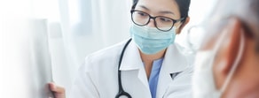 A healthcare professional discusses a medical chart with a colleague, highlighting medbridge's role in hybrid care education.