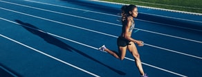 A woman runs on a blue track, embodying medbridge's commitment to precision and dedication in patient care software.