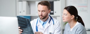 A physician and nurse review an X-ray in a medical office, illustrating effective healthcare training from Medbridge.