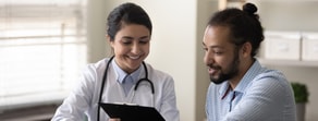 A healthcare professional with a stethoscope and a patient discuss notes, illustrating medbridge's role in digital healthcare.