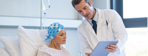 A healthcare professional shows a tablet to a patient with a headscarf, highlighting the efficiency of medbridge digital healthcare.