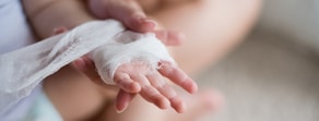 Close-up of a bandaged hand demonstrating healthcare skills, as taught by medbridge.