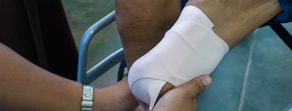 Someone uses their Medbridge training to care for a bandaged leg.
