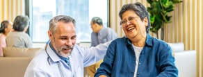 Healthcare professionals and patients share smiles and laughter in a friendly setting enhanced by medbridge software.