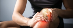 A person using Medbridge digital tools for knee pain relief, with the joint pain area highlighted.