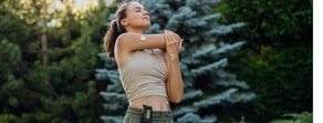 A woman stretches outdoors with wearable devices, demonstrating medbridge’s hybrid care benefits.