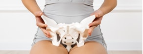 A person demonstrates healthcare training using a pelvic bone model, highlighting its role in digital health environments for medbridge.