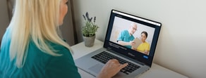 A blonde person at a desk uses a laptop for a medbridge healthcare education video call.