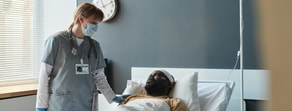 A healthcare worker uses medbridge software to care for a patient on oxygen in a hospital room.