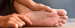 Hands massaging the sole of a foot with a neutral background, representing medbridge techniques.