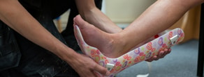 Fitting a colorful orthotic device onto a foot, showcasing hybrid care solutions at medbridge.