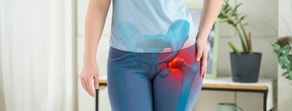 A person stands with a highlighted right hip joint, symbolizing discomfort in a tech-inspired wellness setting, presented by medbridge.