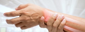 A person holds their wrist, highlighting the need for medbridge patient care software.