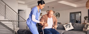 Medbridge caregiver assists elderly man in a living room.