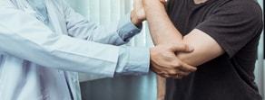 A healthcare professional examines a patient's arm during medbridge training.