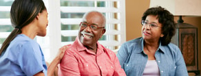 A healthcare worker discusses Medbridge's hybrid care options with an elderly couple.