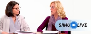 Two women sit at a table reviewing papers with a simulive logo in the corner.