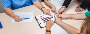 People review bar charts and papers while discussing healthcare education with medbridge.