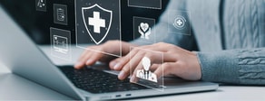 Person typing on a laptop with healthcare icons, hinting at medbridge patient care software.